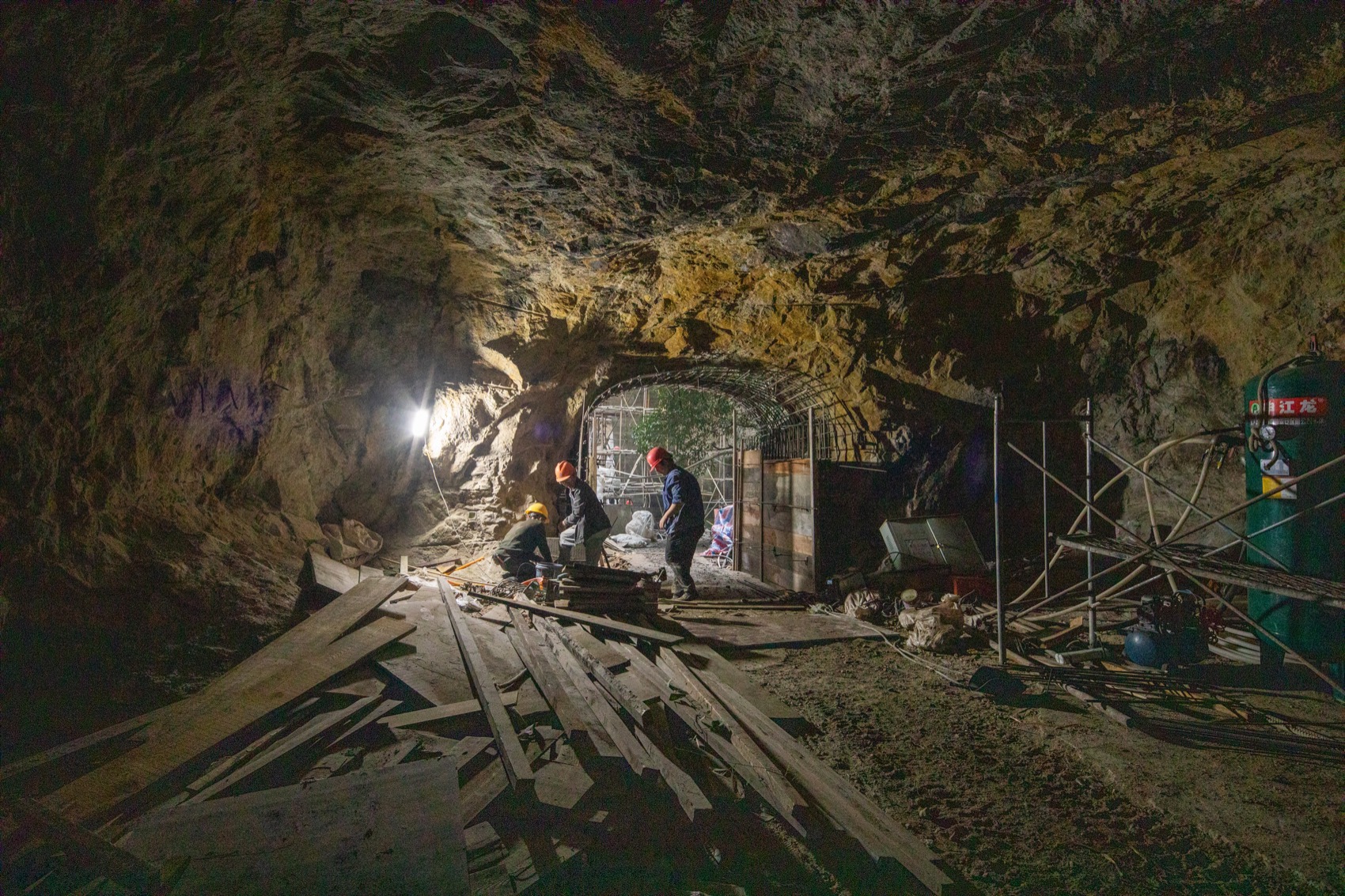Workers assembling timber components inside a quarry tunnel