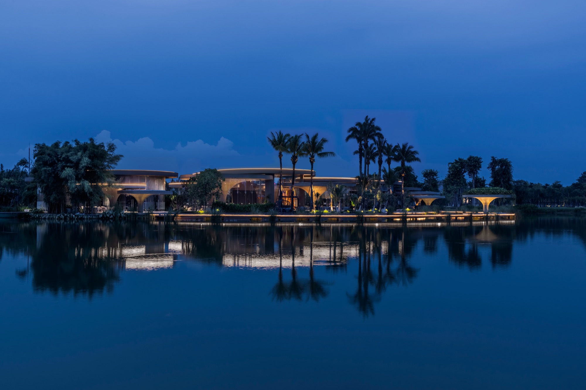 Lakefront at night with the low pavilions reflected in the water