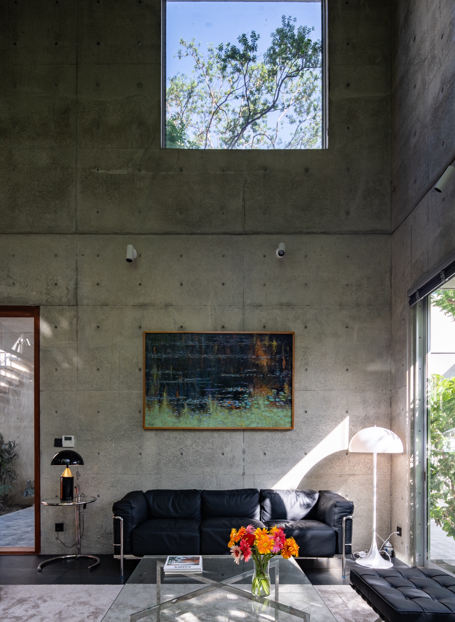 Living room under a high concrete wall and skylight