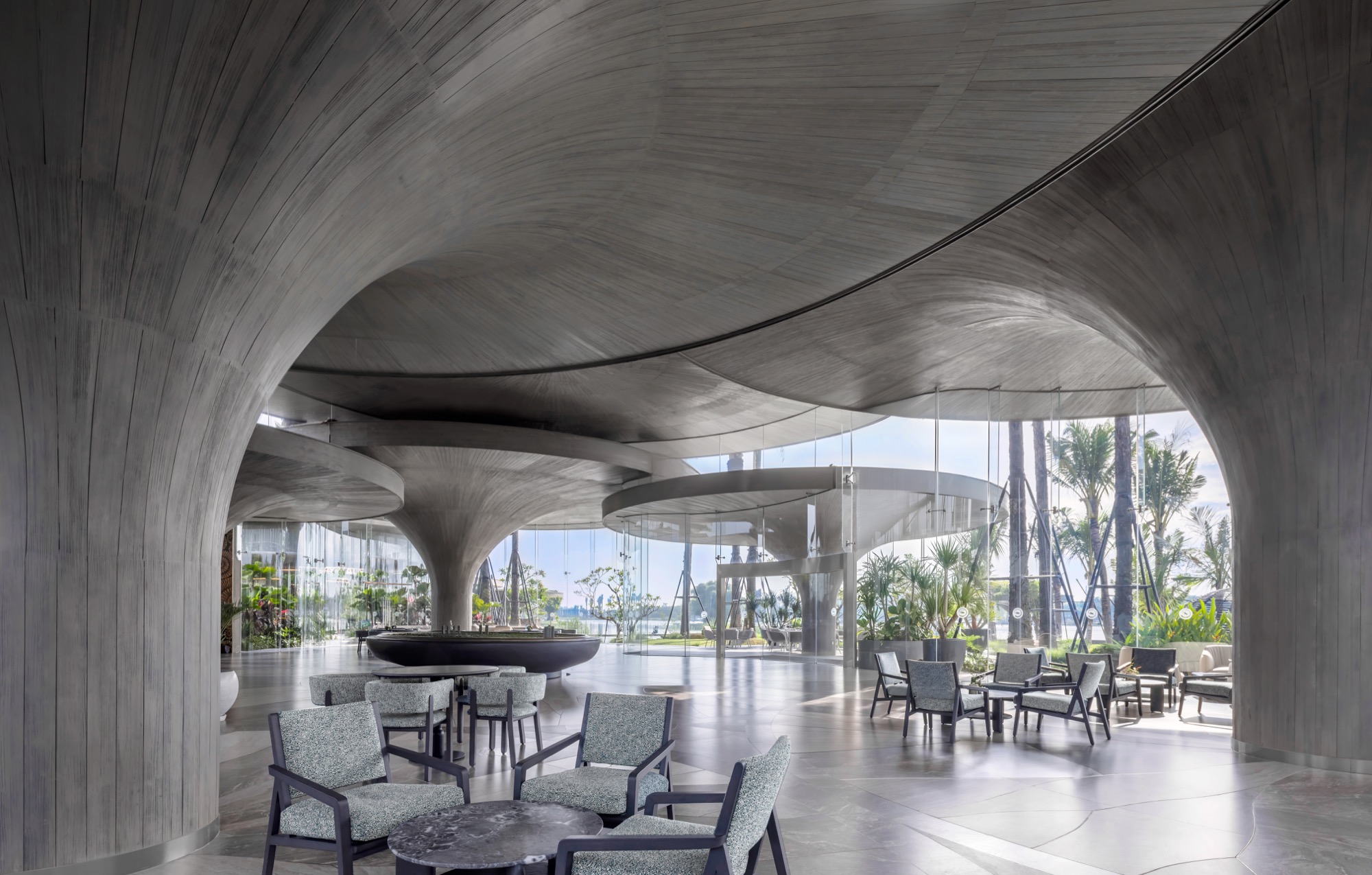 Interior under curved concrete roofs, with views out to the garden