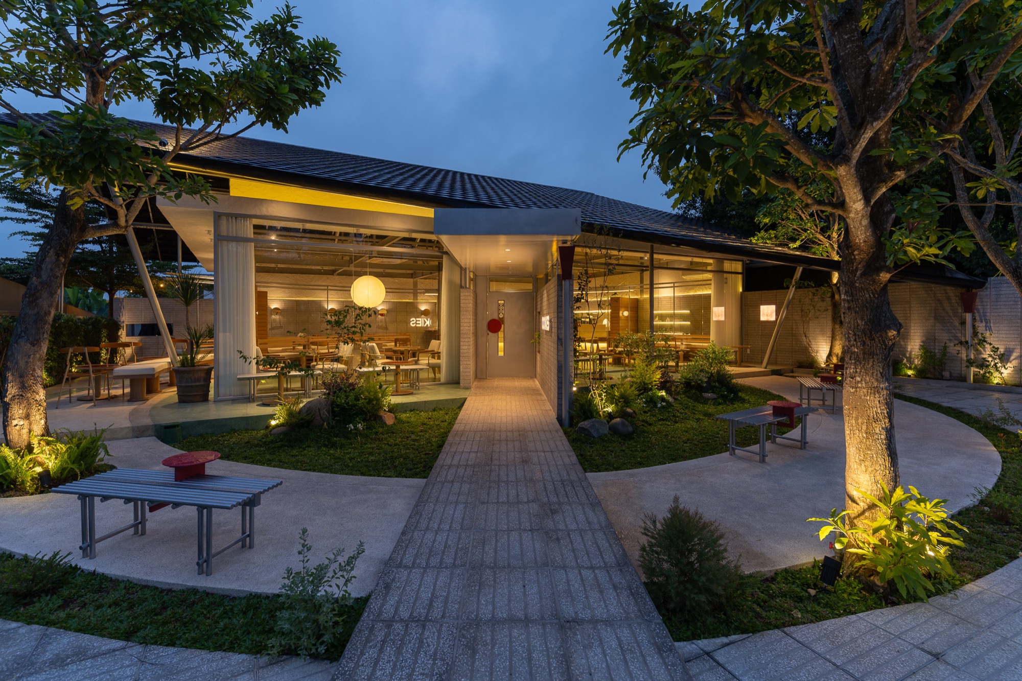 Path through the garden to the glazed café at dusk