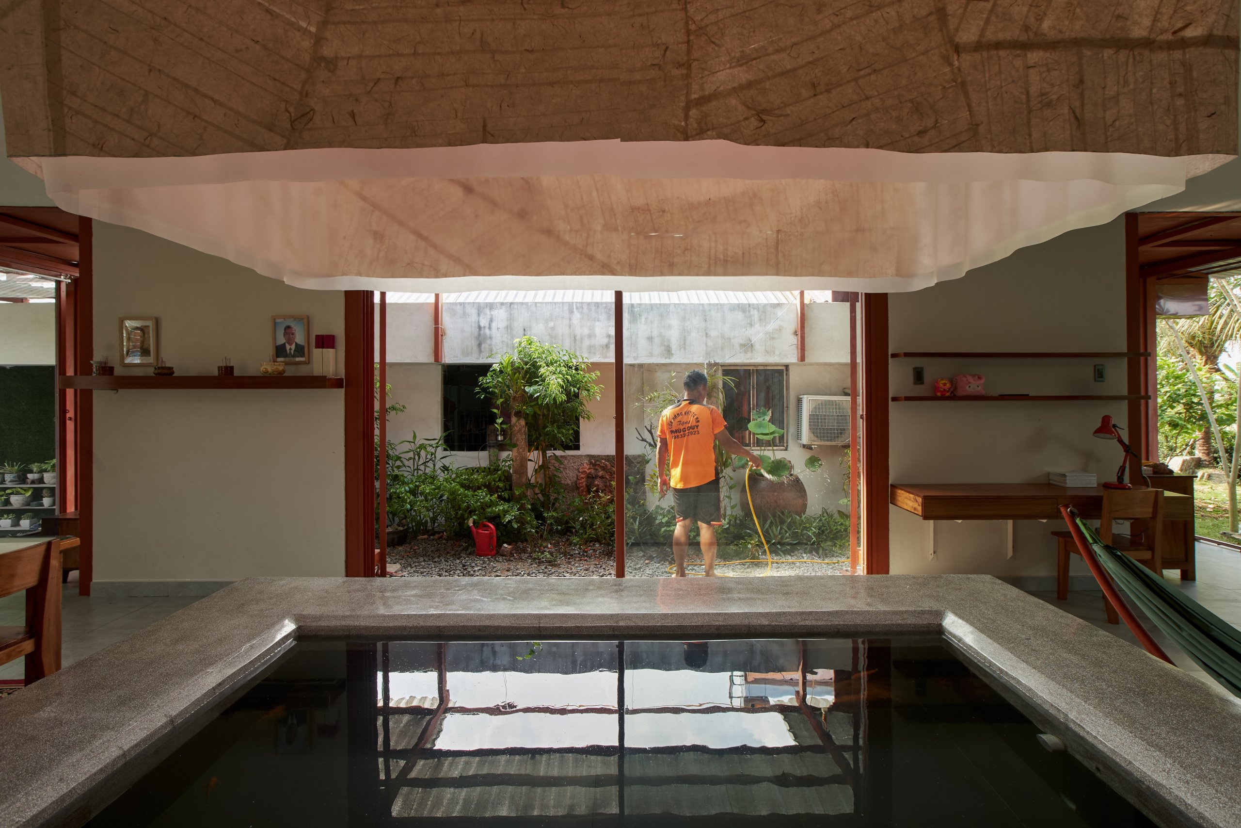 Garden House by aha.studio.arc, Go Quao, An Giang, fish pond at the centre of the shared space